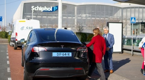 reizigers op luchthaven die een Schiphol taxi bestellen