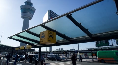 man op bankje aan het wachten op taxi Schiphol